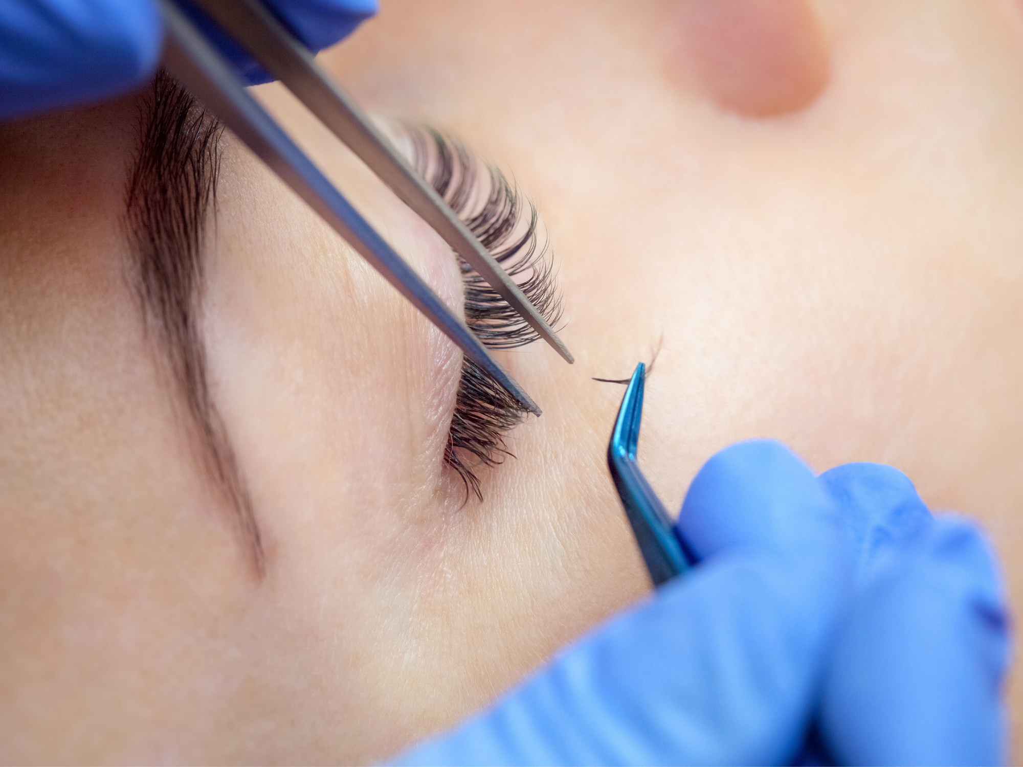 Jeune femme en train de se faire poser des cils afin de les étoffer.