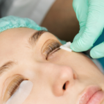 Esthéticienne en train de pratiquer la technique du lash filler pour recourber les cils d'une cliente. location de salle